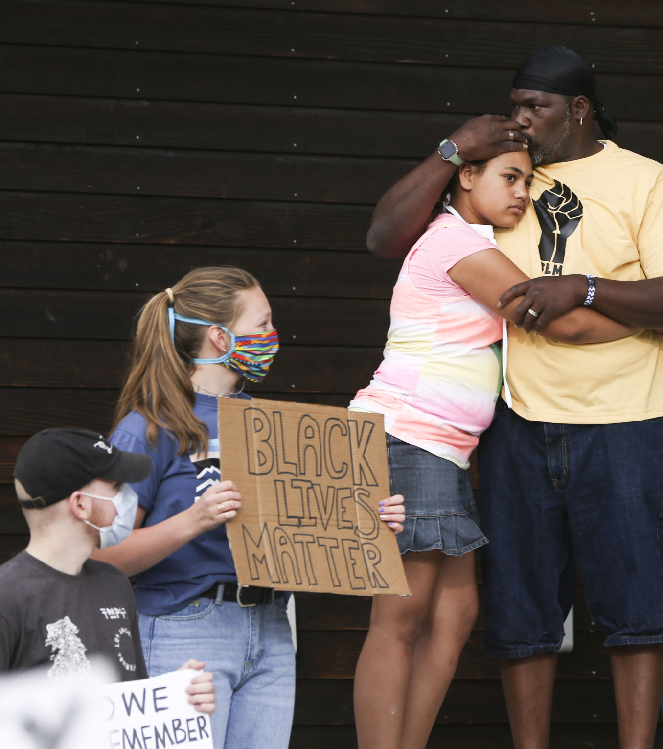 Kevin Thomas hugs his daughter Karma, 12, as speakers talked to the crowd